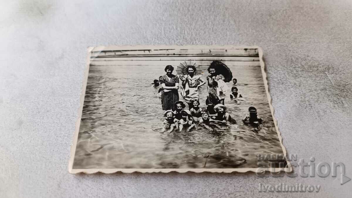 Foto Femei și copii pe plajă