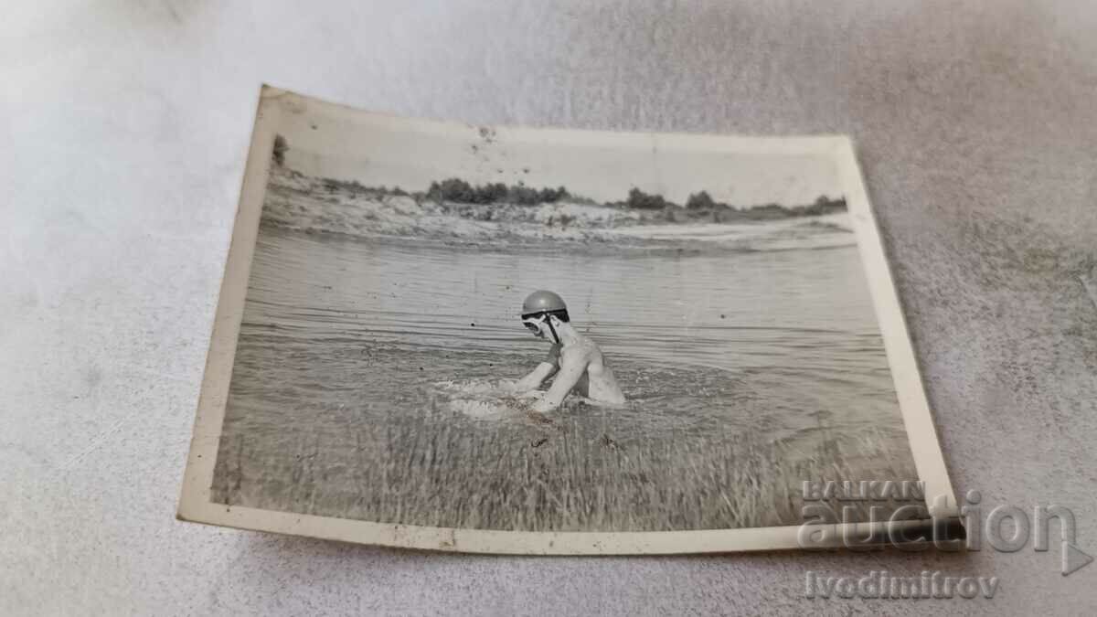 Photo Boy with a helmet in a lake
