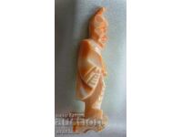 Aztec priest figure from a red snail shell