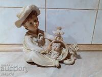 A great beautiful figurine of a boy with puppies and a dove