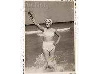 България Снимка на млада жена по бански, къпеща се в морето.