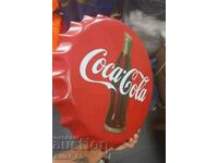 Metal sign in the shape of a Coca Cola cap