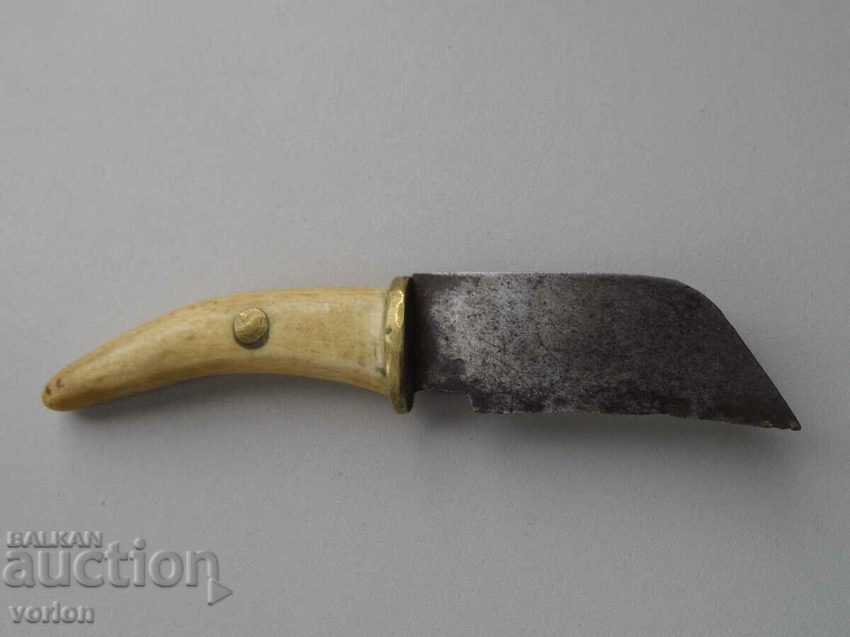 Un mic cuțit vechi, lucrat manual, cu mâner de os.