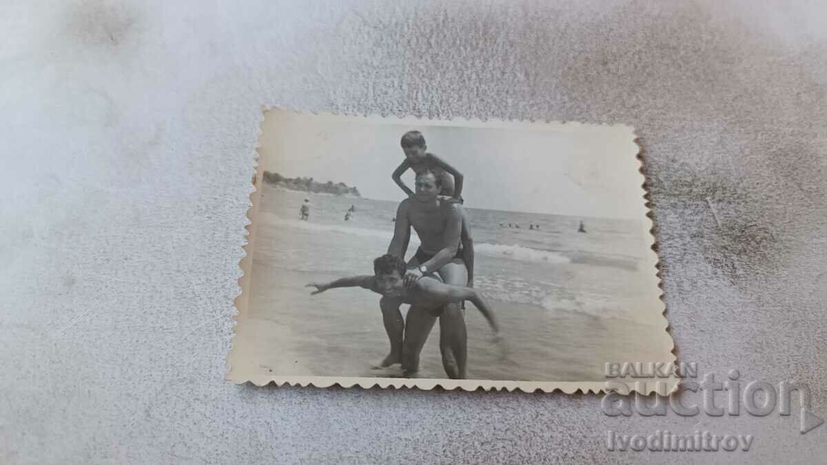 Снимка Двама мъже и момче на брега на морето