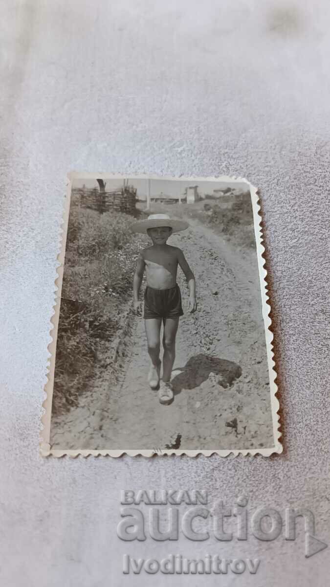 Foto Băiat în pantaloni scurți pe drum