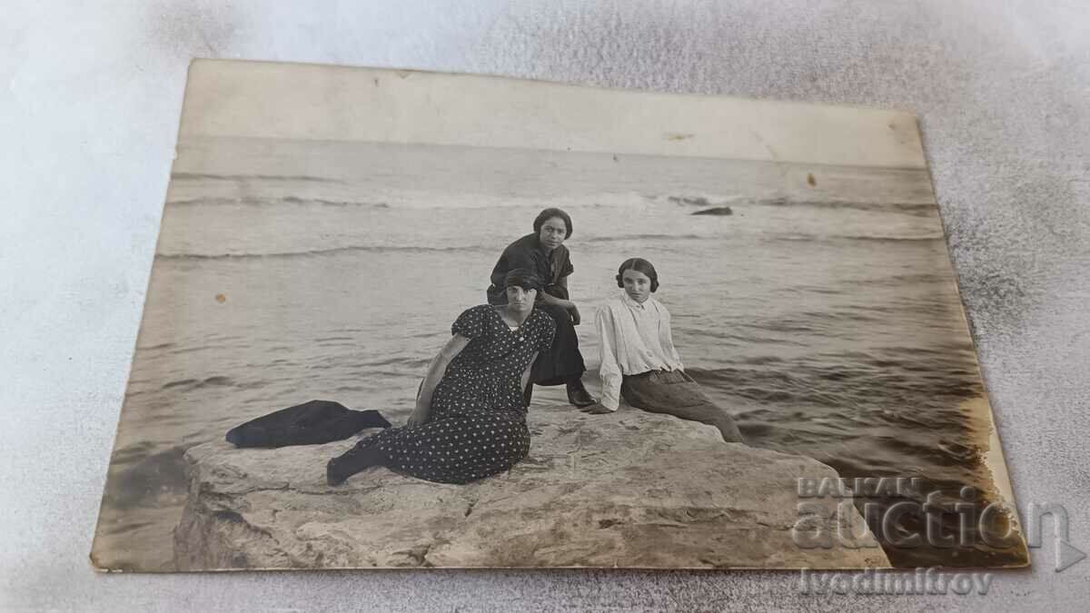 Снимка Три млади момичета на скала до брега на морето