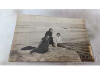 Φωτογραφία Τρία νεαρά κορίτσια σε έναν απότομο βράχο δίπλα στη θάλασσα