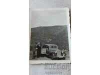 Η κυρία Αξιωματικός και δύο άνδρες με ένα vintage αυτοκίνητο με αριθμό κυκλοφορίας SF 4255