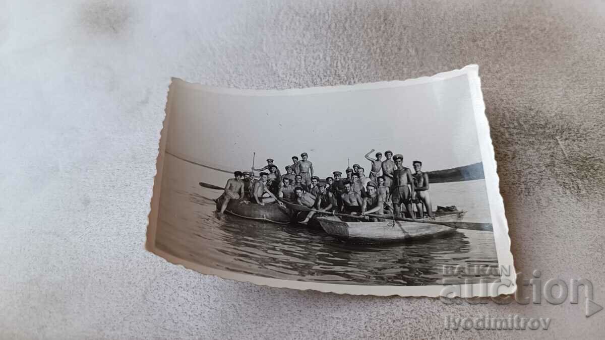 Foto Bărbați și tineri în costume de baie pe două bărci în mare
