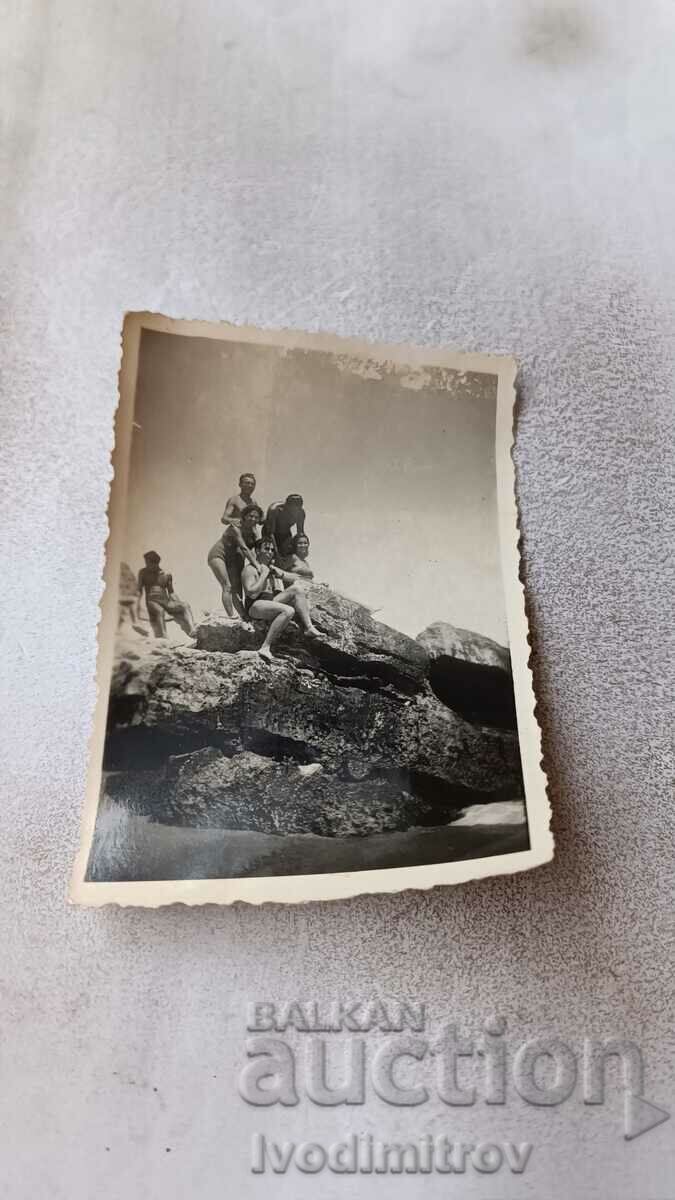 Photo Men and women on a cliff above the sea