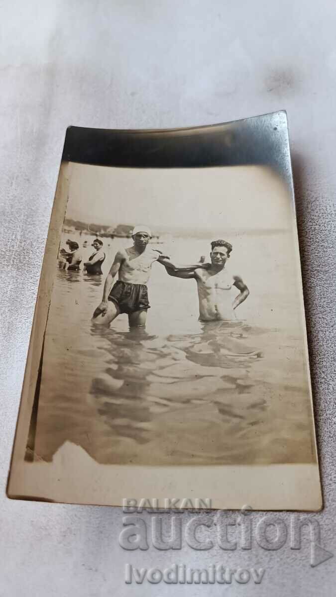 Foto Doi bărbați în costume de baie retro pe plajă