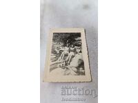 Fotografie Un bărbat și două fete tinere pe o piatră în albia unui râu