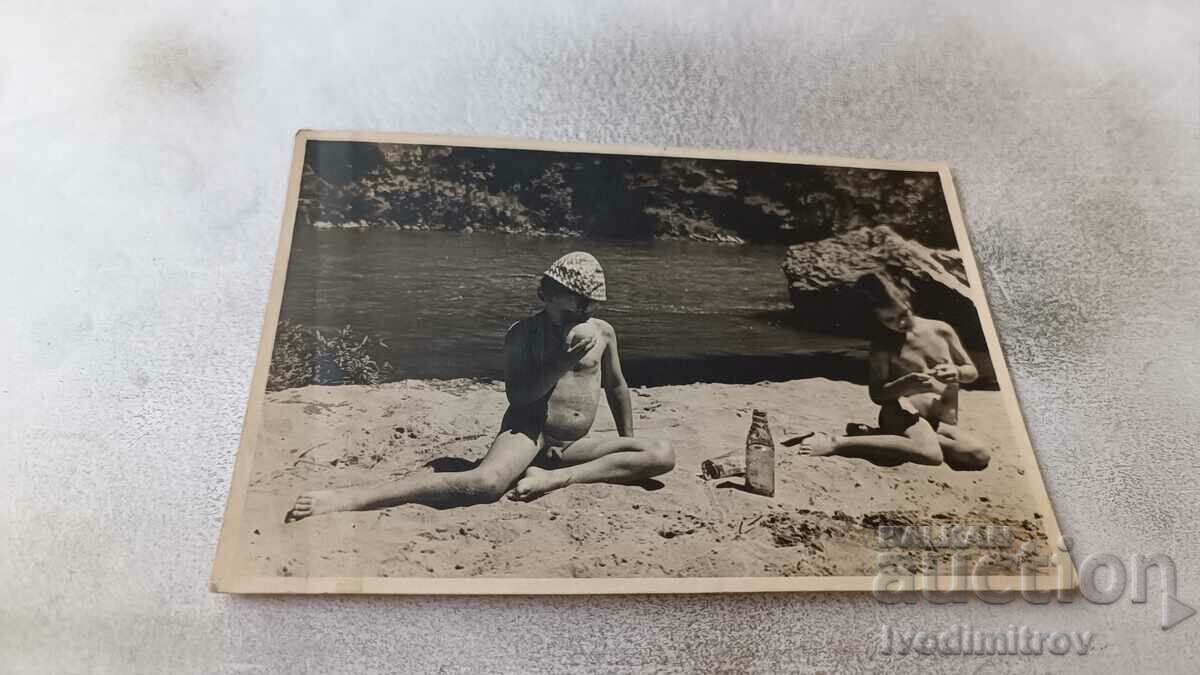 Photo Boy and girl on the sand by the river