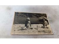 Foto Băiat și fată pe nisipul de lângă râu