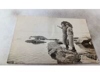 Fotografie Două tinere pe o piatră lângă mare