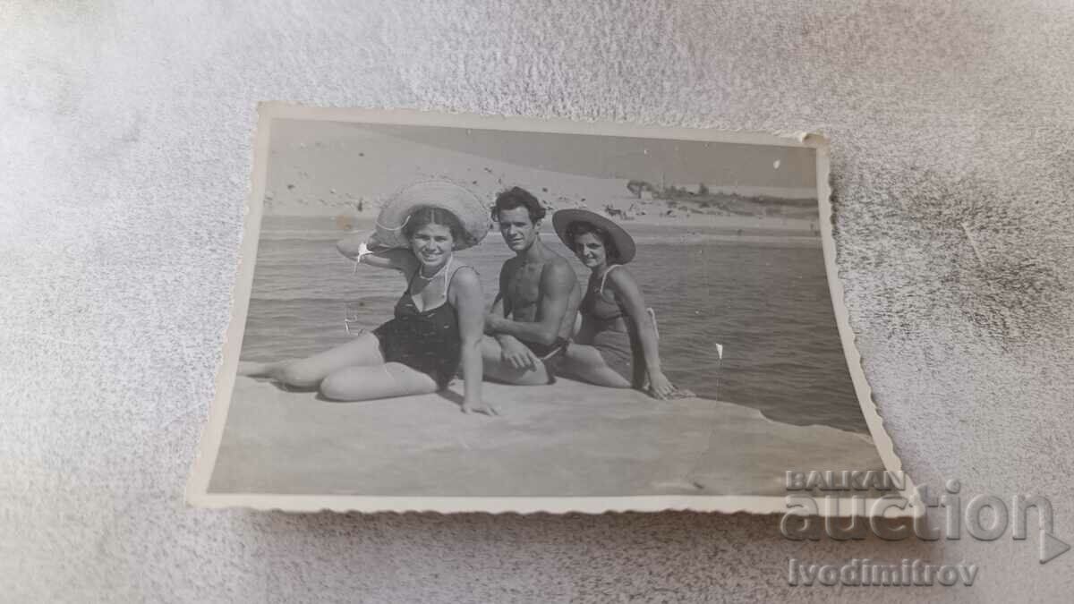 Fotografie Un tânăr și două fete pe o stâncă deasupra mării