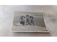 Φωτογραφία Ένας νεαρός άνδρας και δύο κορίτσια σε έναν γκρεμό πάνω από τη θάλασσα