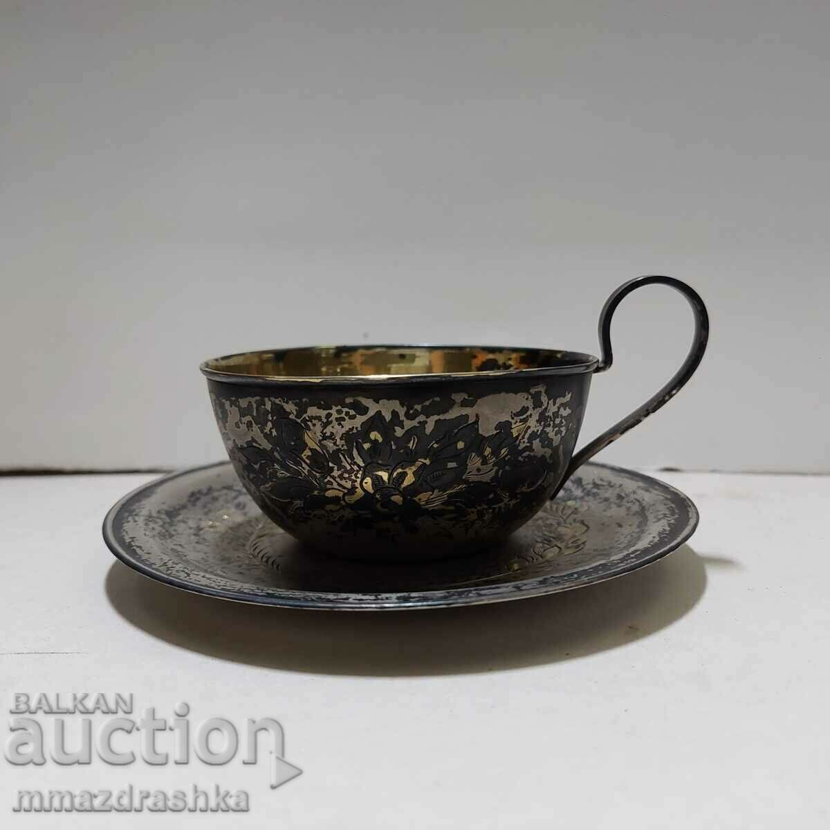 Silver tea cup and saucer