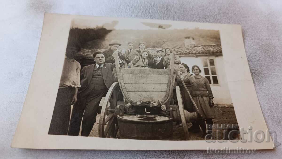 Foto Bărbați, femei și copii pe o căruță în curte