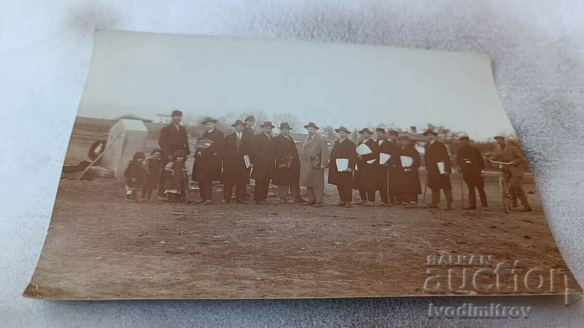 Photo Men with folders under their arms at the end of the village