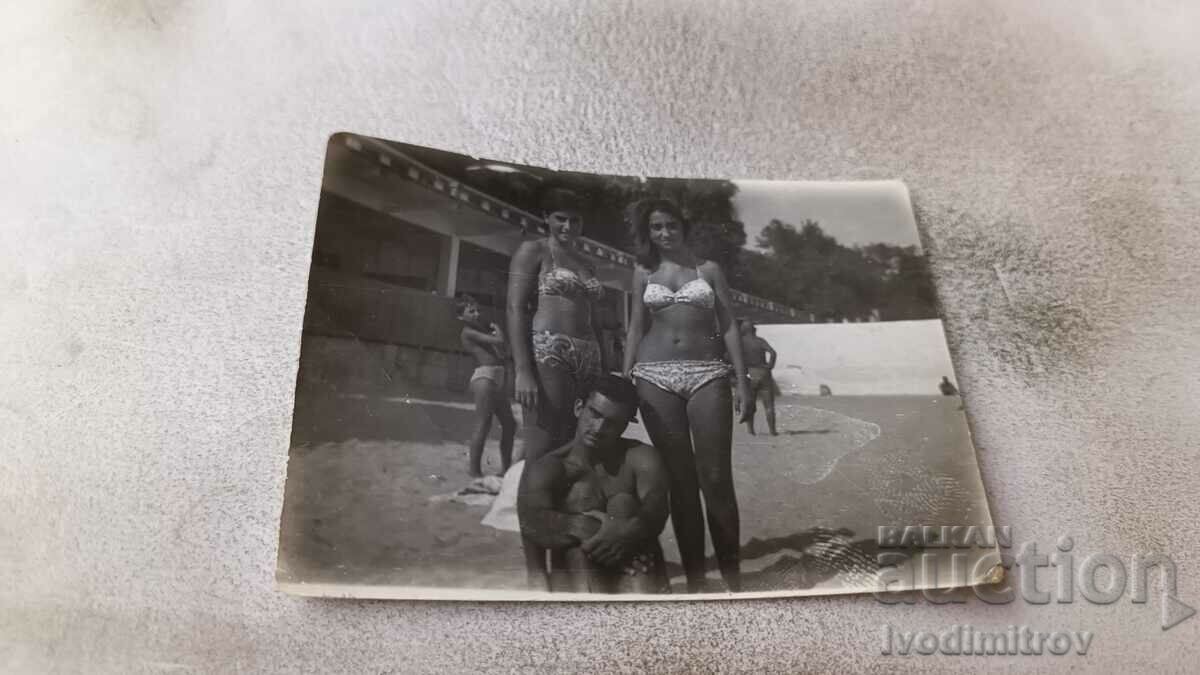 Φωτογραφία Ένας νεαρός άνδρας και δύο νεαρές γυναίκες στην παραλία