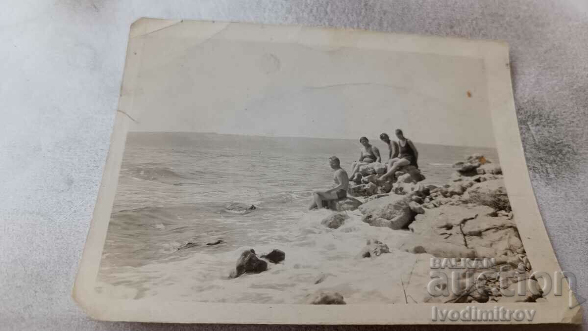 Photo Young men and women on rocks by the seashore