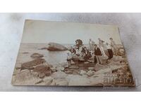 Φωτογραφία Άνδρες γυναίκες και αγόρι σε βράχια δίπλα στη θάλασσα