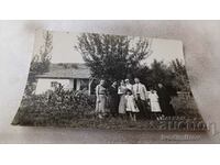 Снимка Мъж жени и две момичета в двора на къщата си