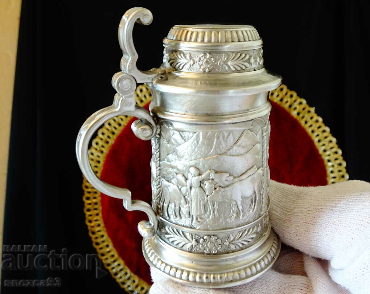 Pewter mug with three village paintings. Pewter mug with three village paintings.