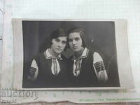 An old photo of two schoolgirls in folk costumes