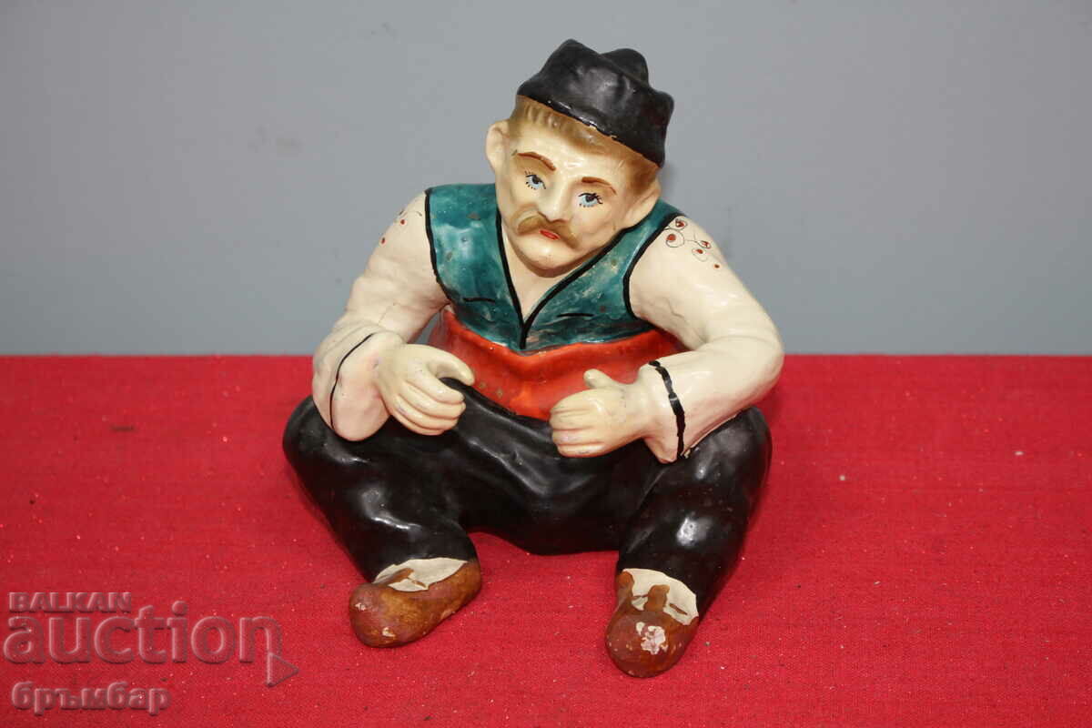 Old Bulgarian ceramic figure of a man wearing a dancer's costume.