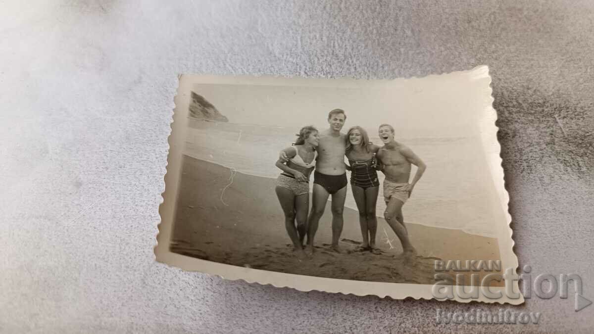 Photo Two young men and two girls on the beach