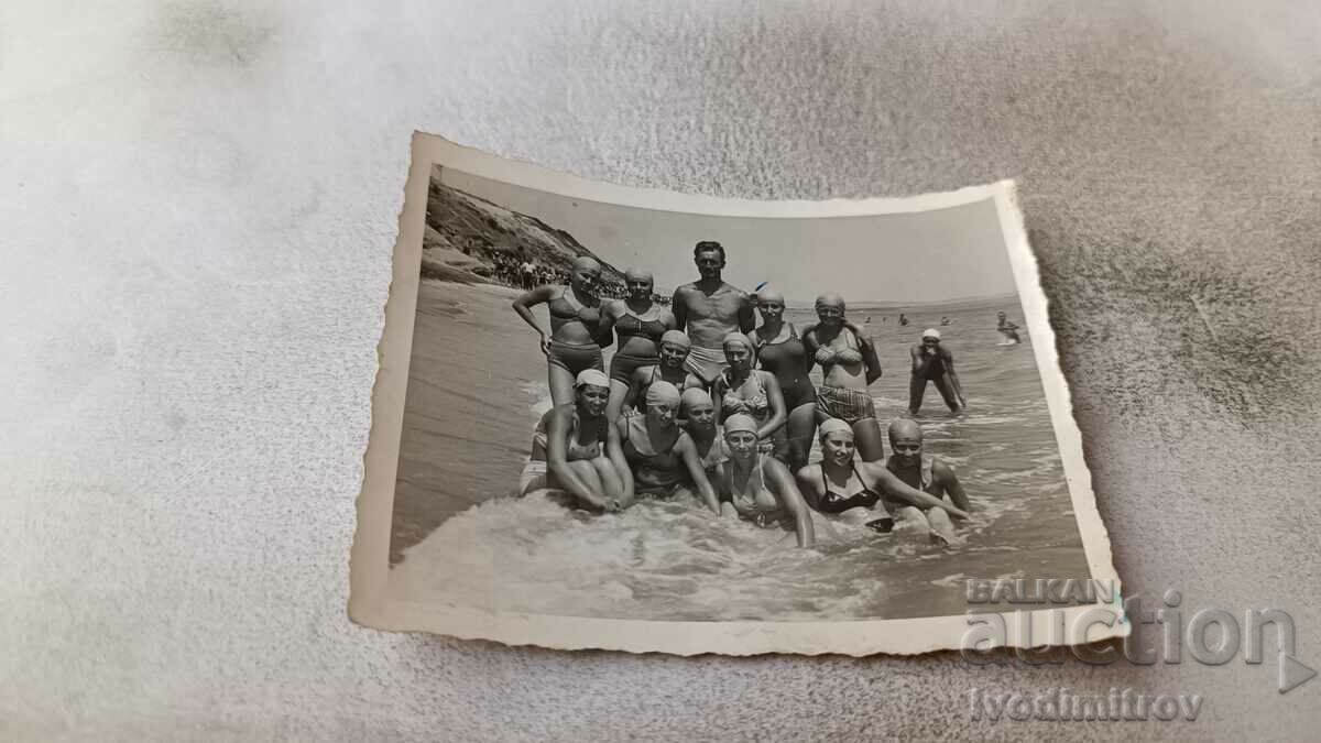 Снимка Мъж и млади момичета по бански на брега на морето