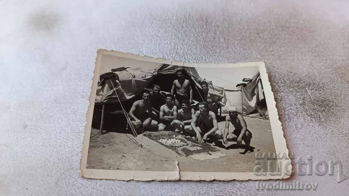 Foto Soldații în pantaloni scurți în fața unui cort