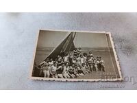 Foto Femei și fete în fața unei bărci cu pânze în mare
