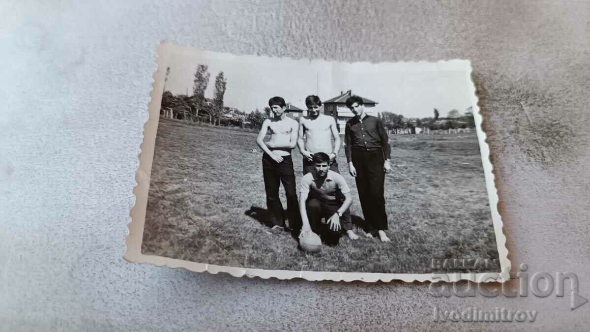 Photo Four young people with a soccer ball