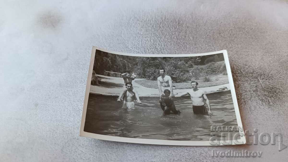 Photo Man and boys in swimwear in a swimming pool