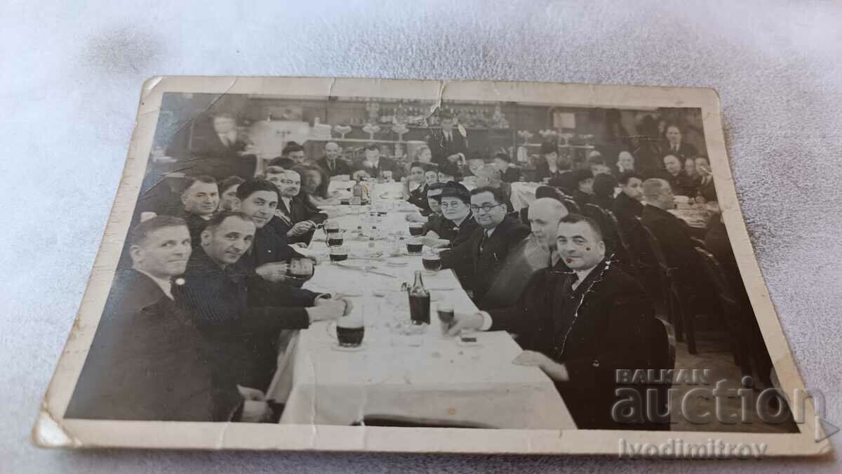 Φωτογραφία Σοφία Άνδρες και γυναίκες σε ένα εορταστικό γεύμα σε ένα εστιατόριο