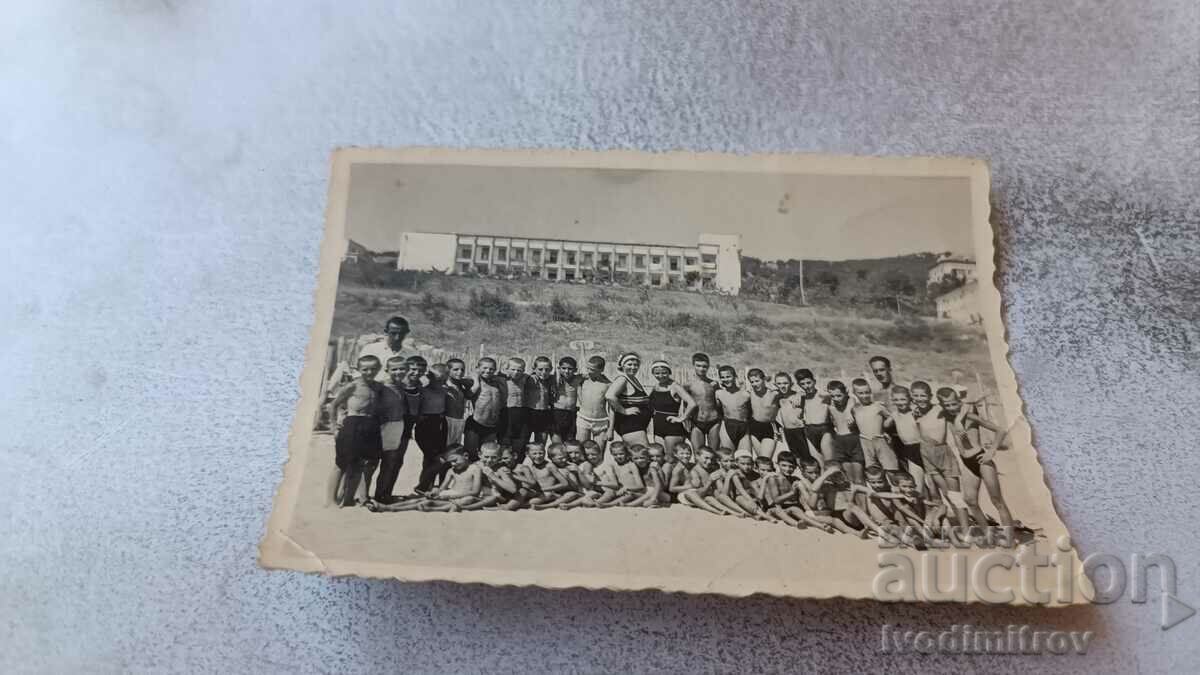 Foto Studenți și profesori pe plajă în fața unei stații de odihnă