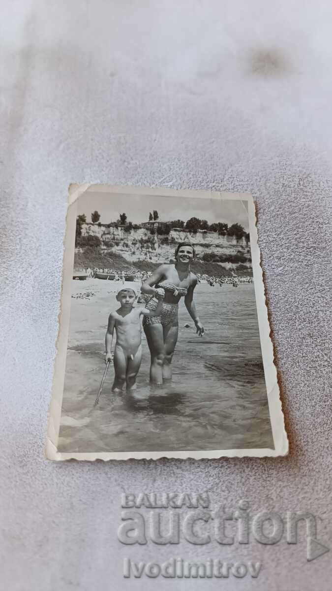Photo A young woman and a little boy on the beach