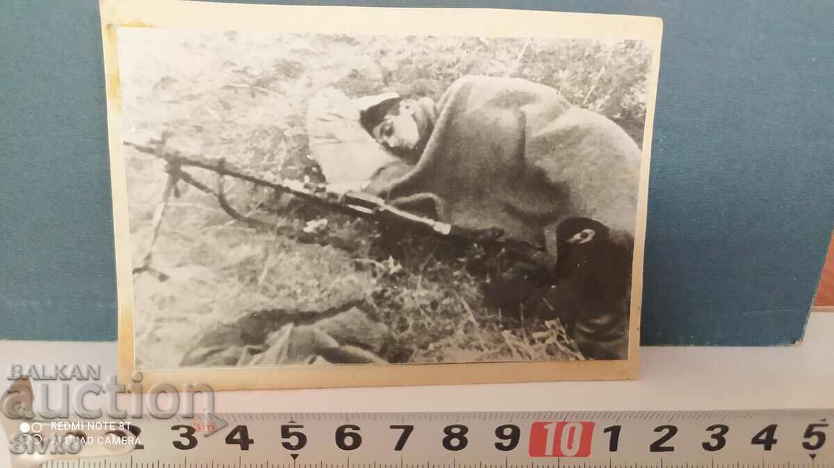 Φωτογραφία ενός στρατιώτη που κοιμάται δίπλα σε ένα πολυβόλο