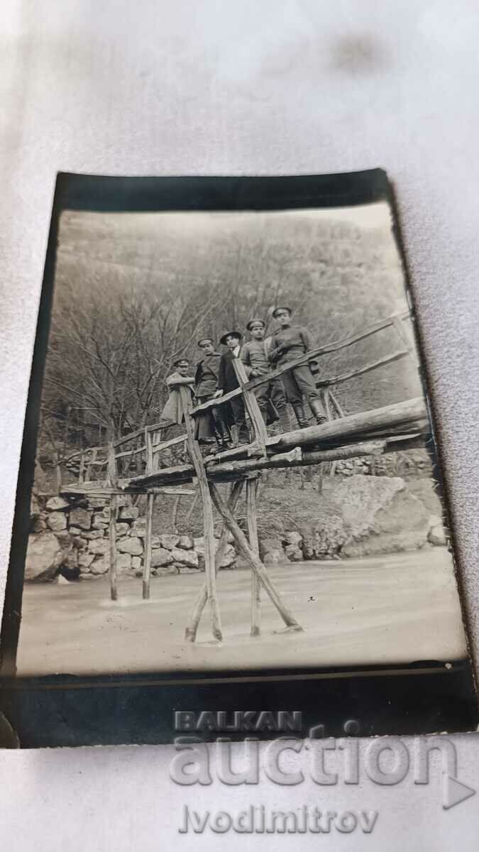 Photo Dolno Pavlikene Officers and a man on a tree. a bridge over a river