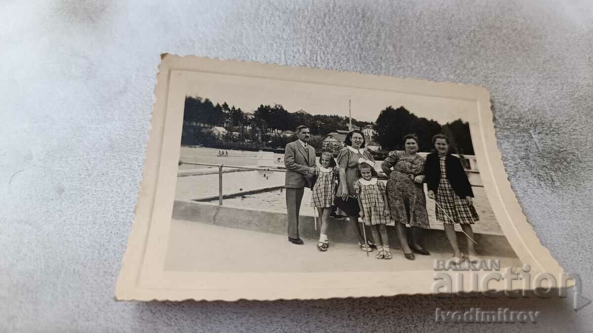 Photo Lying Man women and children in front of the pool