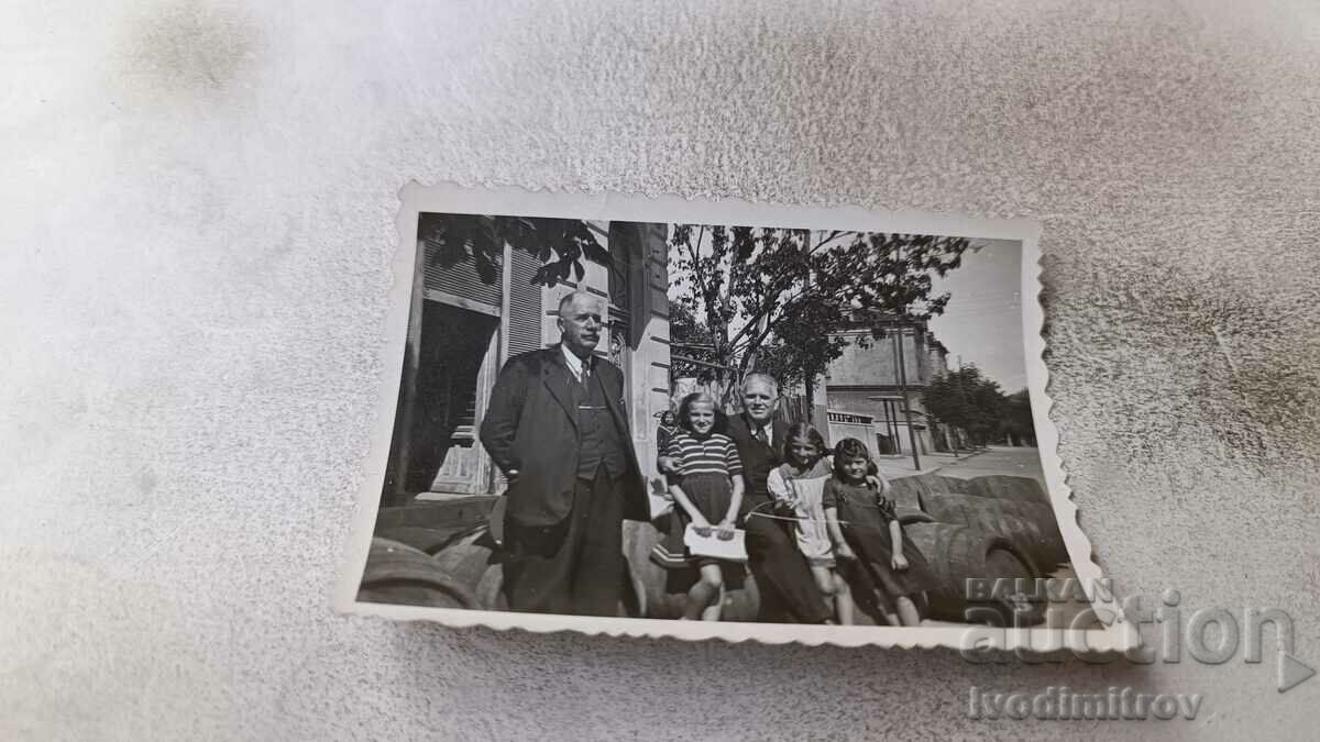 Снимка София Двама мъже и три деца пред дървени бурета