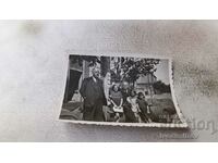 Снимка София Двама мъже и три деца пред дървени бурета