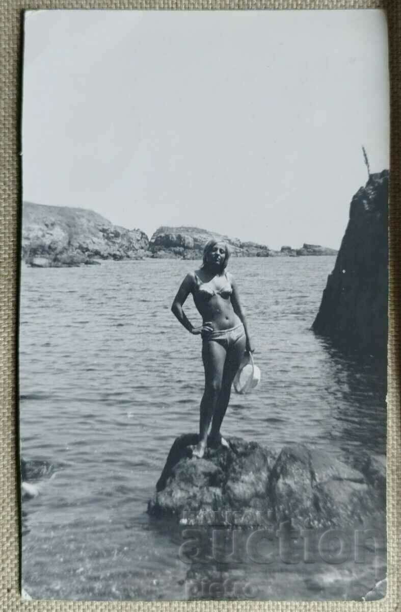 Снимка фотография на млада жена по бански костюм на скали...