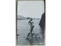 Φωτογραφία φωτογραφίας νεαρής γυναίκας με μαγιό σε βράχια...