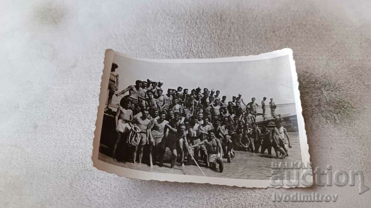 Foto Bărbați și tineri în costume de baie pe plajă