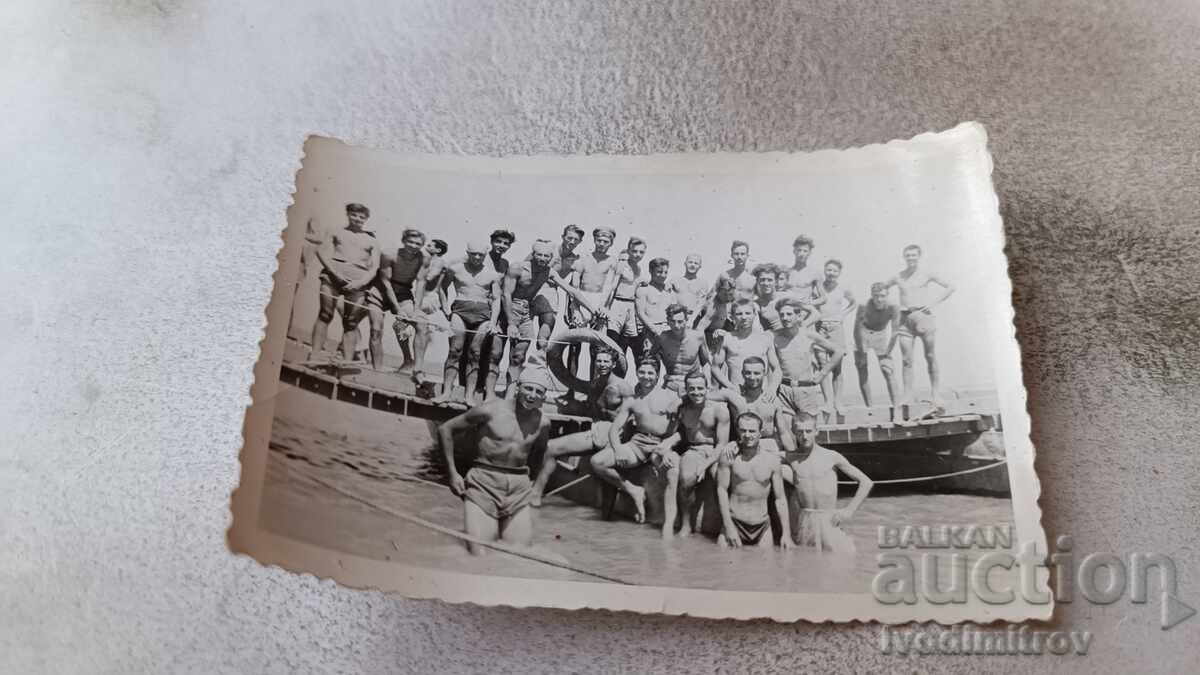 Foto Bărbați și tineri în costume de baie pe plajă