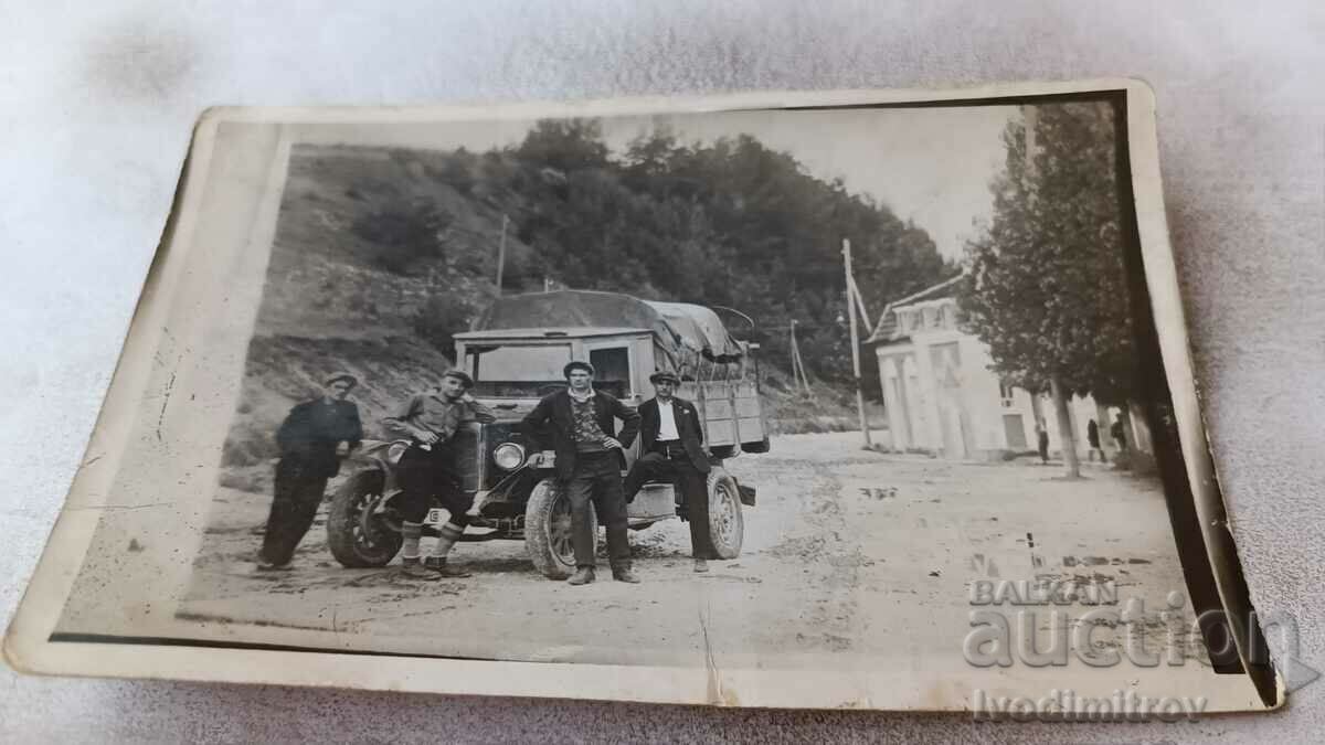 Fotografie Patru bărbați în fața unui tov retro. mașină cu număr de înmatriculare Sf